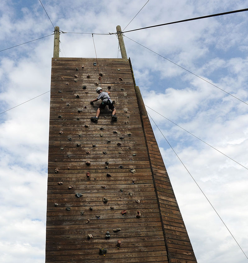 A Manitou camper has almost reached the top of the climbing tower