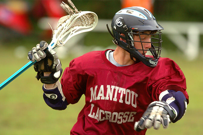 A camper plays lacrosse at Camp Manitou for Boys