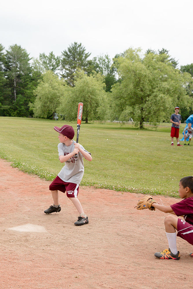 A batter and catcher prepare to receive a pitch from the mound